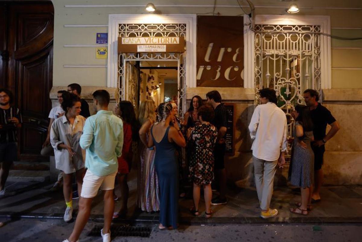 Decenas de personas esperan a las puertas de un local.