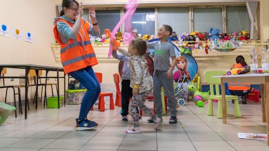 Una voluntaria juega con niños en un espacio de la estructura. | // MARCOS RODRÍGUEZ