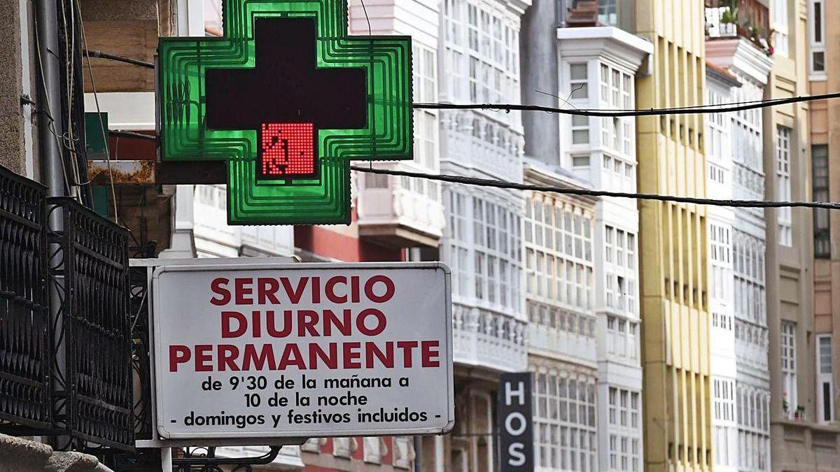 Cruz verde en el exterior de una farmacia, en la céntrica calle Riego de Agua de A Coruña.