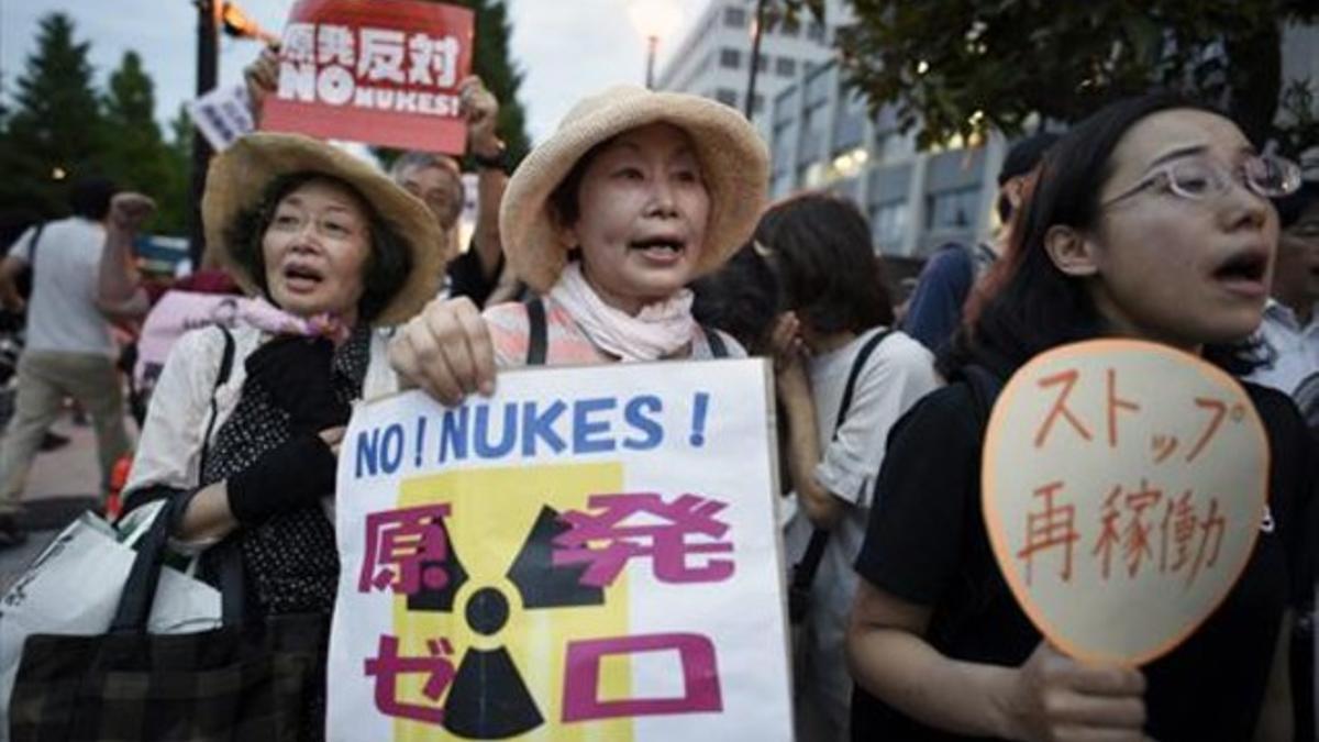 Unas activistas corean consignas contra la reapertura, ayer, en Tokio.