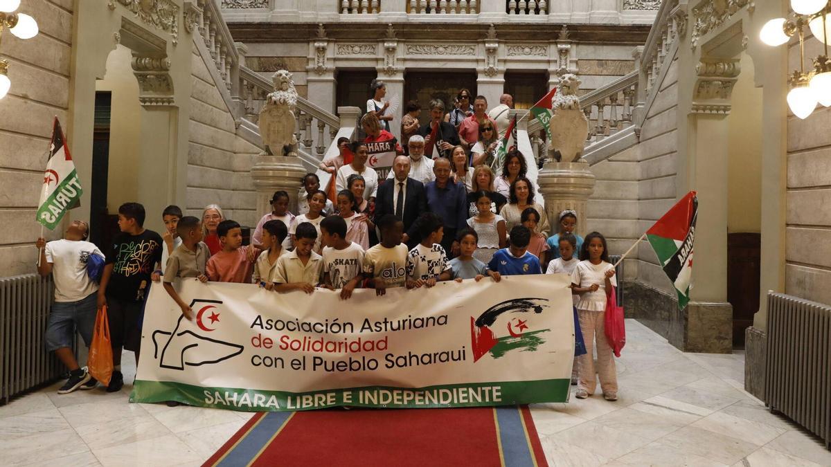 Foto de familia de los treinta niños saharauis con el presidente Juan Cofiño y varios diputados.