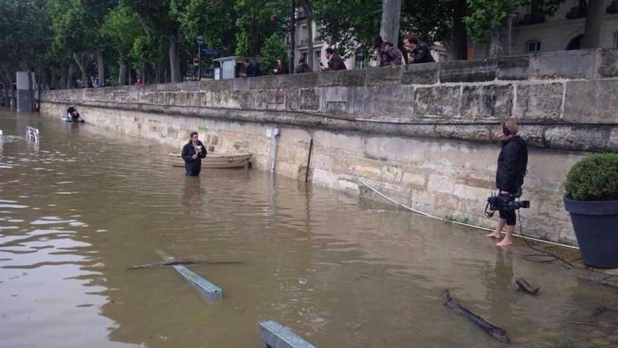 Dos periodistas de France2 en una de las riberas del Sena, por donde habitualmente puede pasearse, ahora completamente inundada.