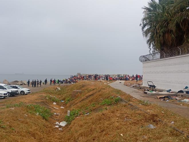 La Policía escolta a los servicios de limpieza en la playa El Trampolín de Ceuta, donde volvieron cientos de inmigrantes