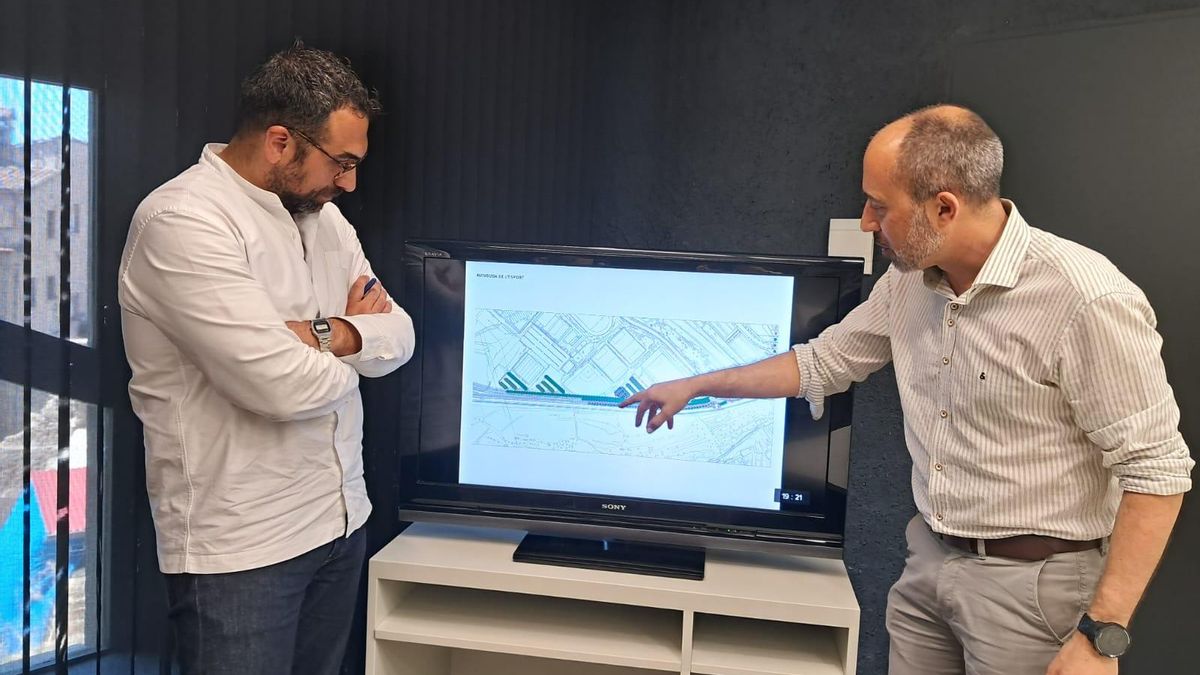El regidor Carles Garcia i l'alcalde Marc Aloy amb un plànol on es veuen les tres zones d'aparcament amb 220 places