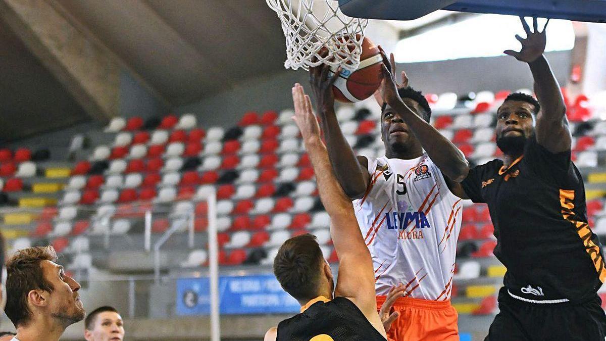 El jugador del Oviedo Baloncesto Norelia, a la derecha, trata de taponar a Badmus, del Coruña, en un amistoso disputado en Riazor; de espaldas, Ferreiro, y a la izquierda Javi Vega.