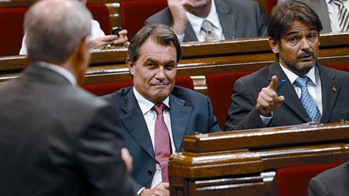 Artur Mas y Oriol Pujol observan a José Montilla, de espaldas, durante la última sesión de control al Govern de la legislatura, ayer en el Parlament.