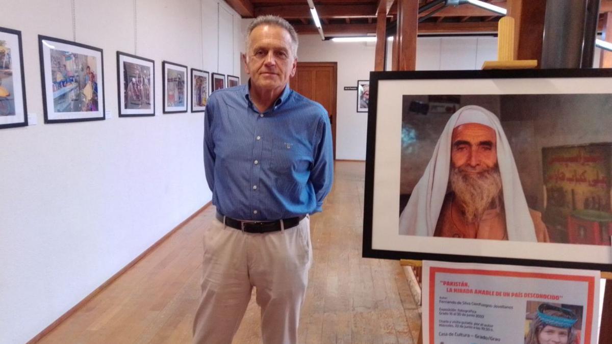 Fernando de Silva, en la Casa de Cultura de Grado, junto a uno de los retratos de la muestra.