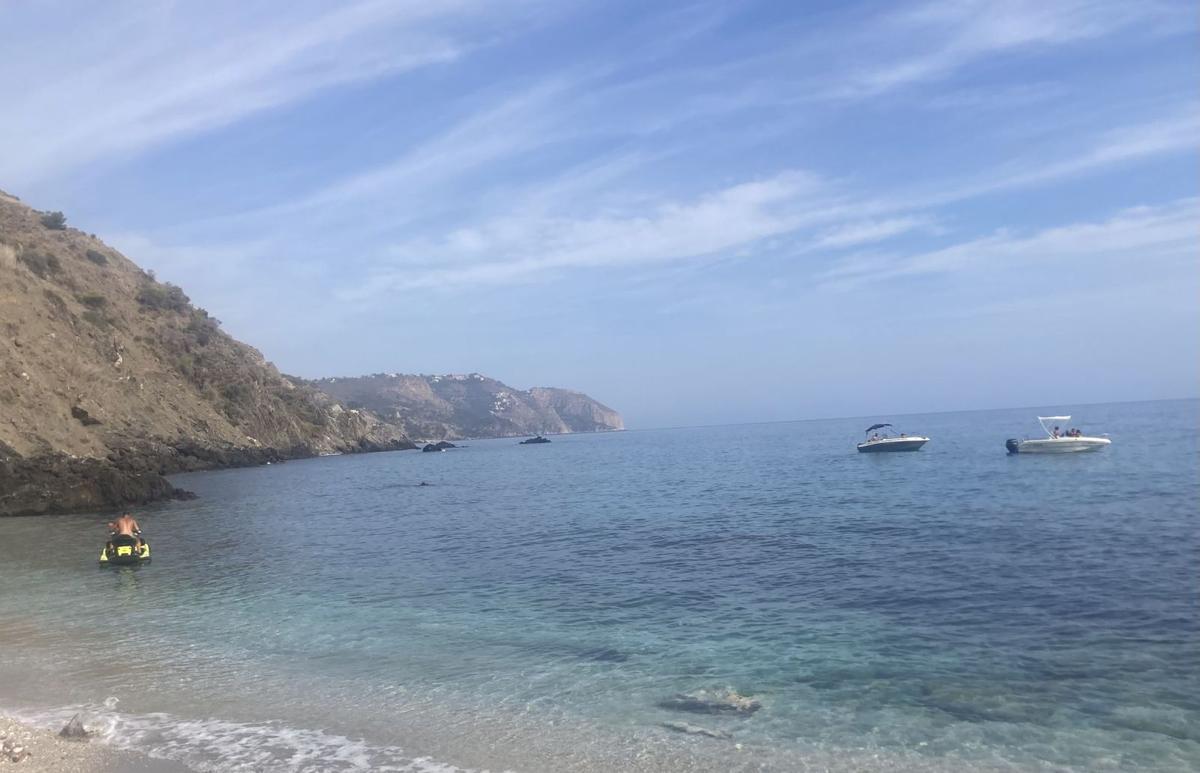 Un usuario de moto acuática navega junto a la orilla ante dos lanchas fondeadas en una zona no permitida.