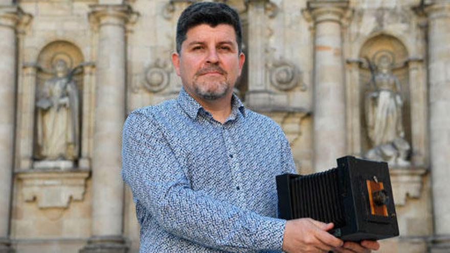 Alfredo Sellier posa con una cámara de sus antepasados frente a la iglesia de San Jorge, donde se casaron Elisa y Marcela.