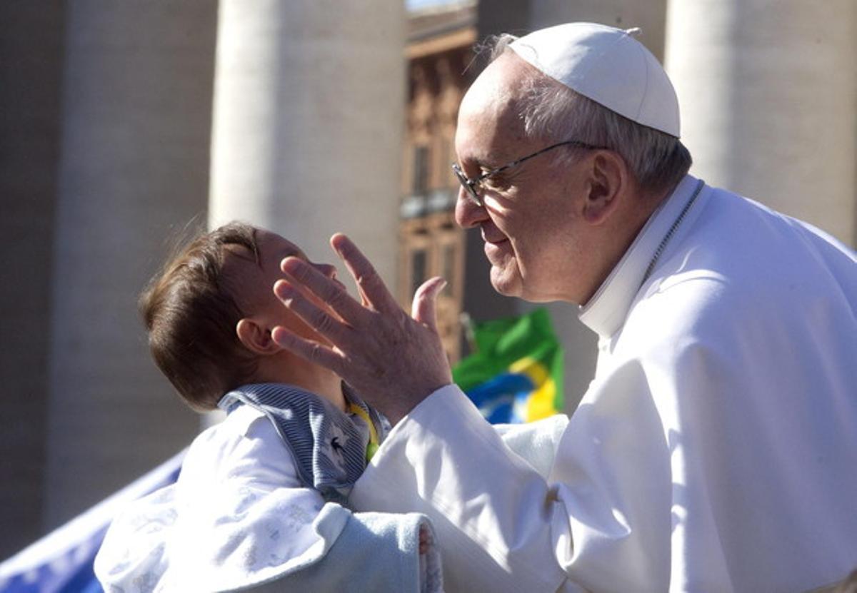 El Papa beneeix un nen a la plaça de Sant Pere.