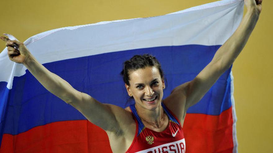 La pertiguista Elena Isinbáyeba, con la bandera de Rusia, tras ganar en los campeonatos del mundo en pista cubierta.