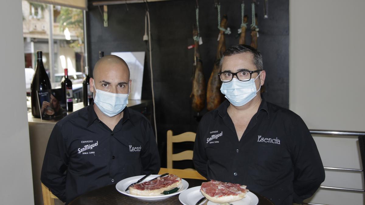 Fulgencio y Roberto Borrella Solera posan con las tostadas en su local de Cáceres.