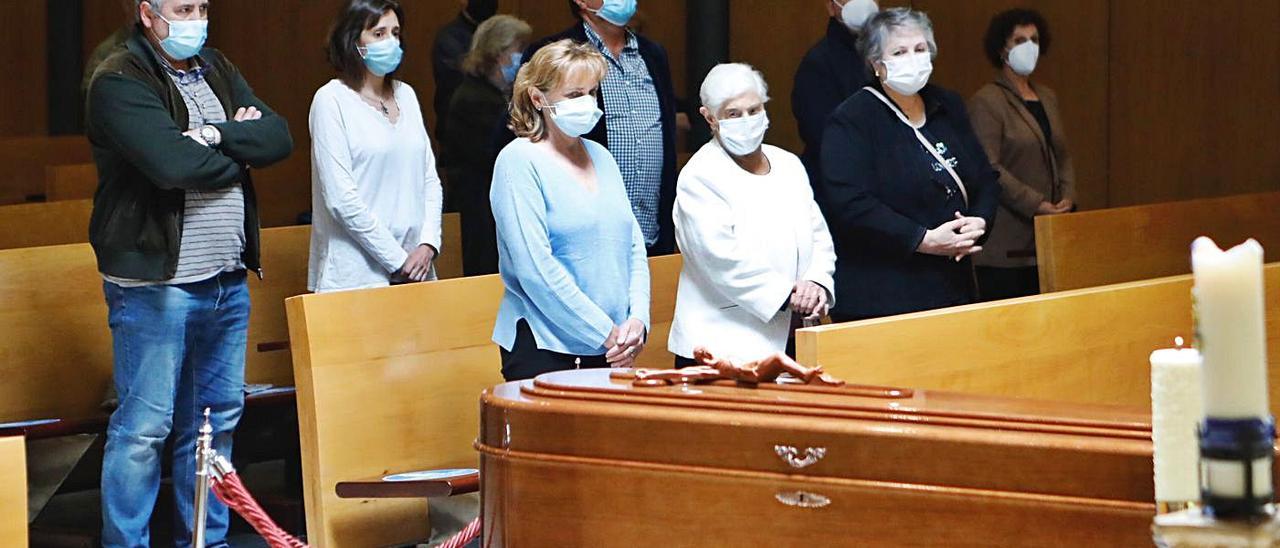 En la primera fila, y por la izquierda, Ángeles Carpena Martínez (hija), María de los Ángeles Martínez (viuda) y Elvira Carpena Martínez observan el féretro de Rufino Carpena durante el funeral en el tanatorio de Cabueñes. | M. León