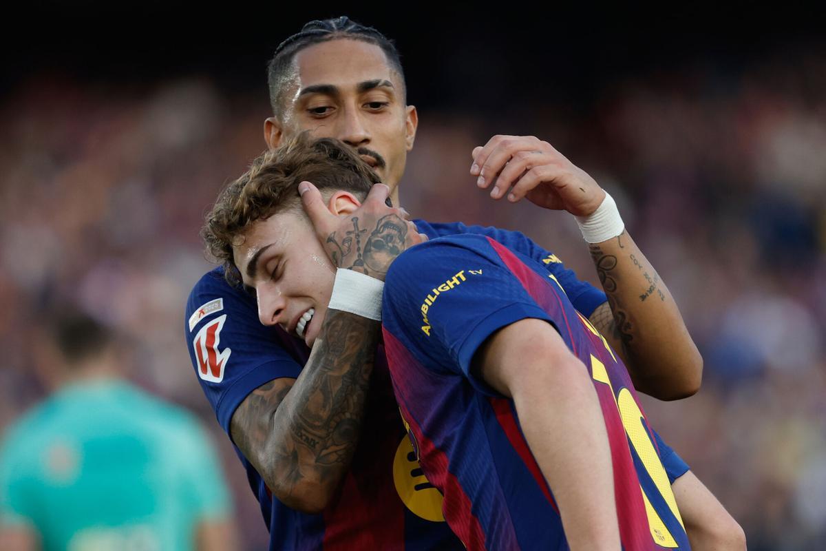 Barcelona's Raphinha hugs Fermin Lopez after a goal during a La Liga soccer match between Barcelona and Levante in Barcelona, Spain, Sunday, Feb. 22, 2026. (AP Photo/Joan Monfort)