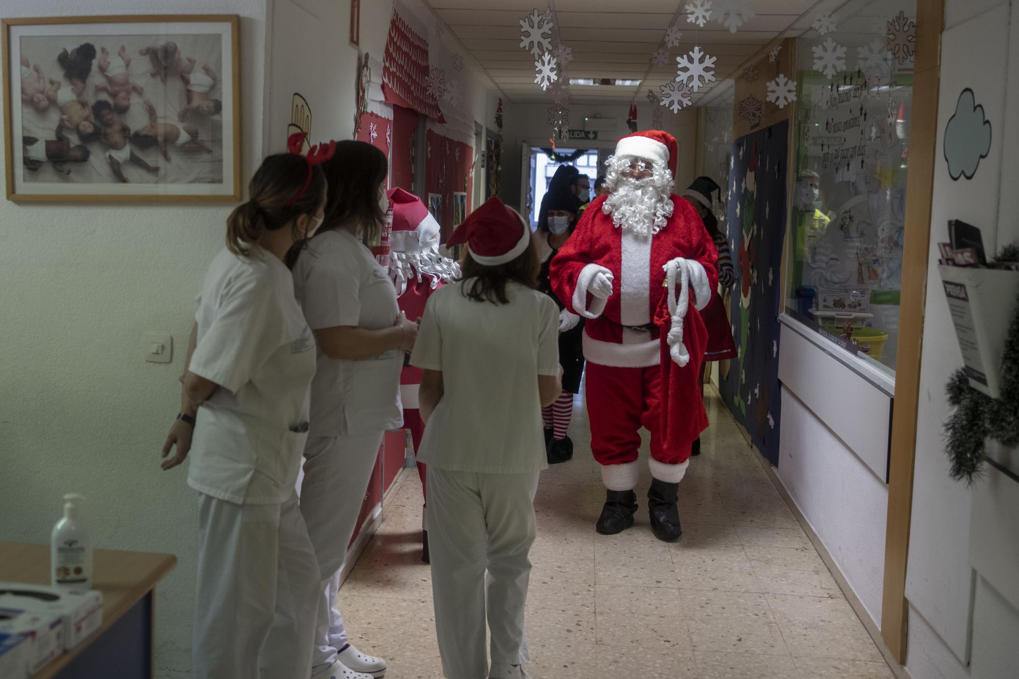 Unas sanitarias observan la llegada de Papá Noel.