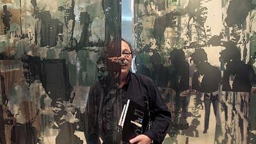 El artista multidisciplinar Alberto Corazón posa entre sus cortinas de vinilo serigrafiadas, que forman parte de su exposición &quot;Obra conceptual, pintura y escultura. 1968-2008&quot;, que se muestra en el Instituto Valenciano de Arte Moderno (IVAM).
