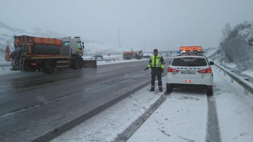 Una patrulla de la Guardia Civil de Tráfico pide precaución en una carretera nevada