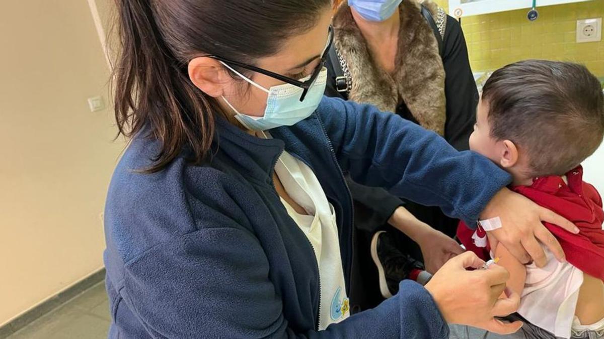 Una enfermera pone la vacuna de la gripe a un niño.   | // FDV