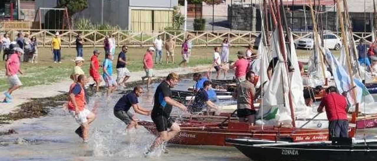 La tradicional regata de Porto Meloxo, en la que es preciso salir corriendo desde la playa antes de empezar a competir en el mar. // Muñiz
