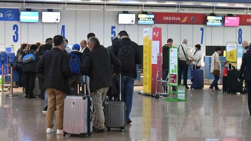 Pasajeros esperan en los mostradores de facturación, en el aeropuerto de Alvedro.