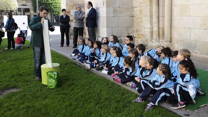 UN MONITOR EXPLICA A UN GRUPO DE NIÑOS LA MANERA DE RECICLAR VIDRIO