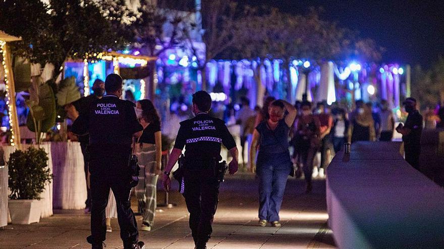 Dos policías controlan el uso de la mascarilla y la distancia de seguridad en La Marina de València.