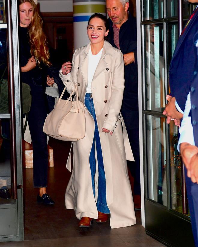 Emilia Clarke con un trench oversized de líneas y colores clásicos durante una jornada en Nueva York