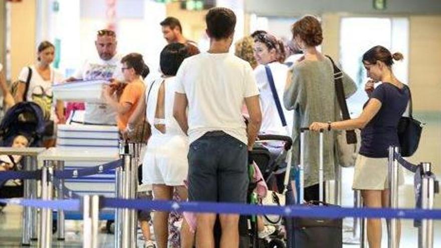 Un grupo de pasajeros hace cola para pasar el filtro de seguridad del aeropuerto.