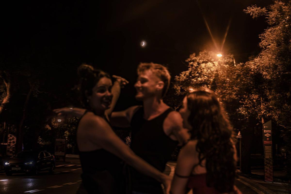 Barcelona 28/08/2026 Sociedad. Jóvenes se encuentran el eclipse lunar al salir de una discoteca en la zona de Montjuic esta madrugada en Barcelona. AUTOR: JORDI OTIX