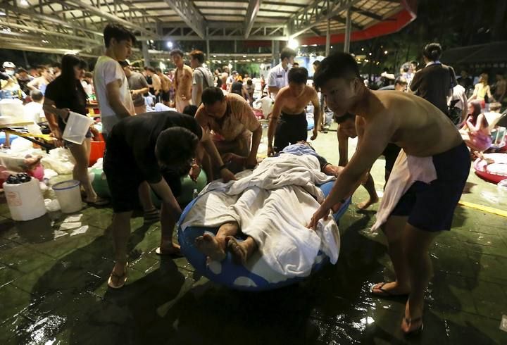 People carry an injured victim from an accidental explosion during a music concert at the Formosa Water Park in New Taipei City