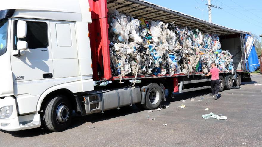 Un operari carrega en un tràiler unes bales de residus a les portes de l&#039;empresa Tirgi de Celrà