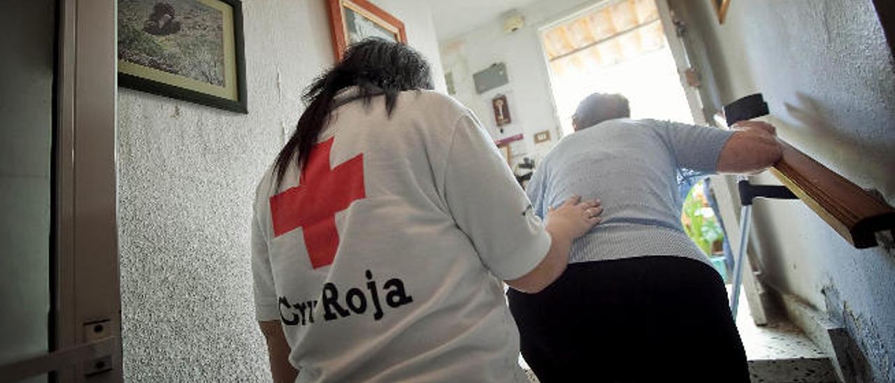 Una voluntaria de Cruz roja cuida a una jubilada canaria.