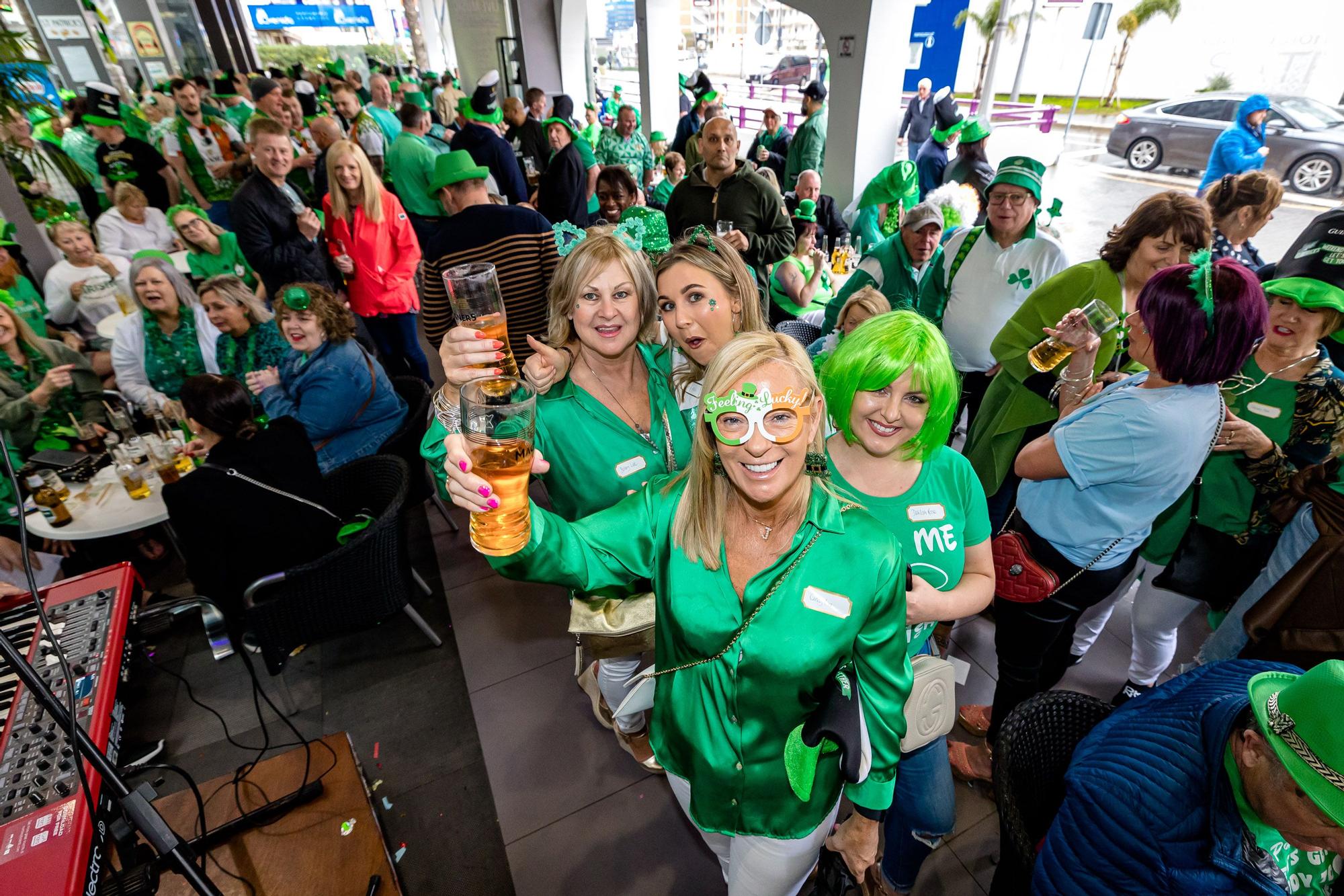 Esta tradicional fiesta llena de verde las calles de la zona inglesa | Los turistas se refugian en terrazas y bares ante las precipitaciones pero no desisten de la celebración