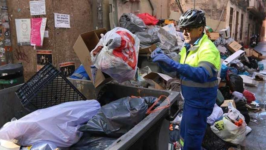 Operarios recogiendo parte de los residuos acumulados durante los últimos días en las calles del Centro.