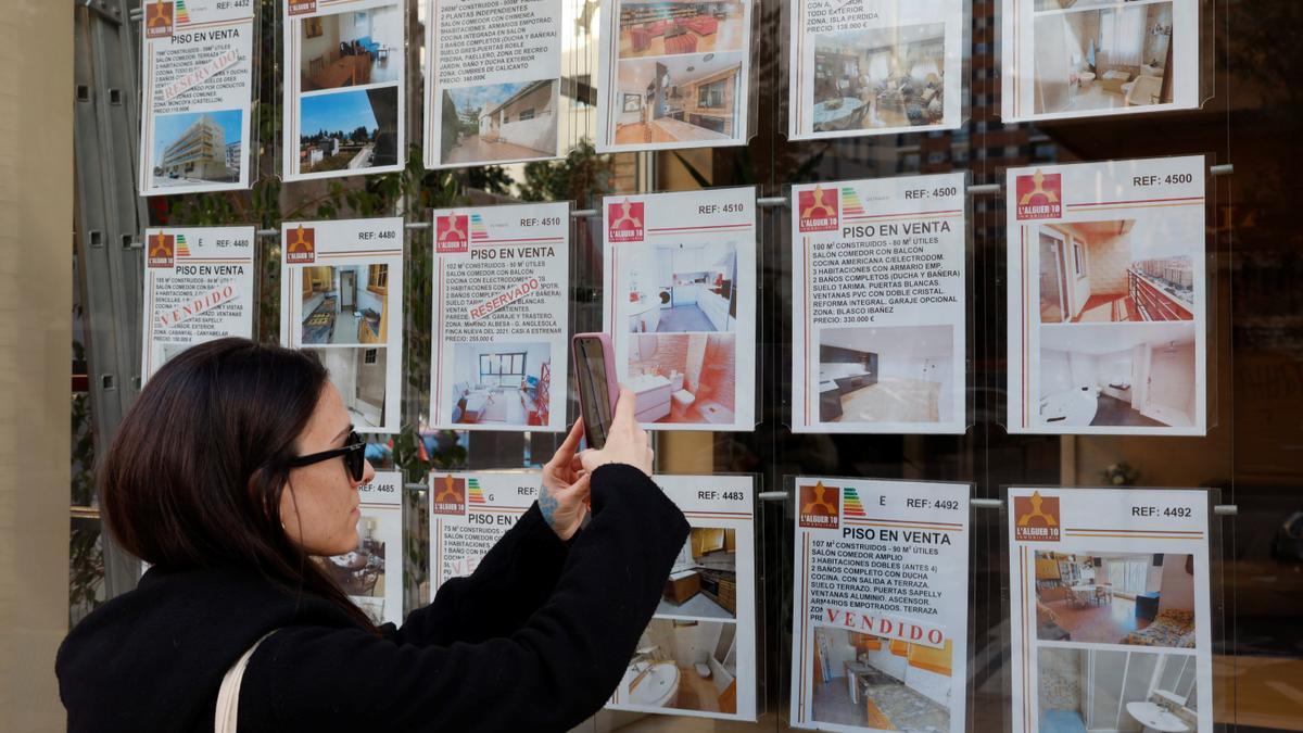 Una mujer está revisando el precio de las viviendas en una inmobiliaria de Valencia. GERMÁN CABALLERO