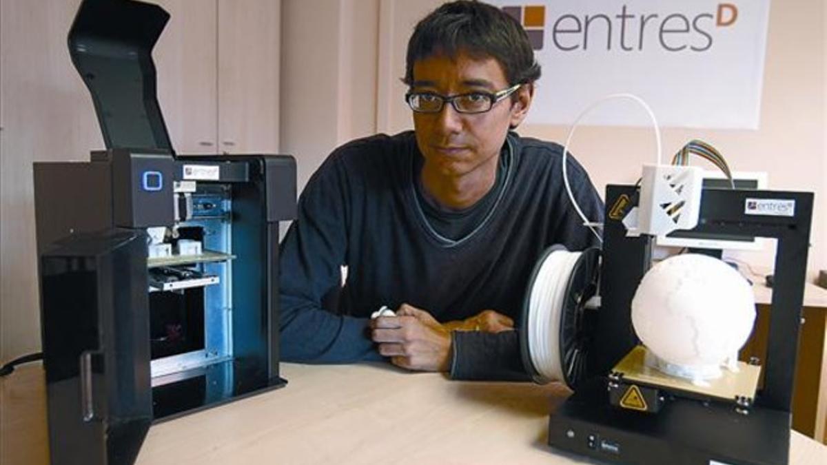 Marc Torras, de la empresa EntresD, posa con dos modelos de impresoras 3-D.