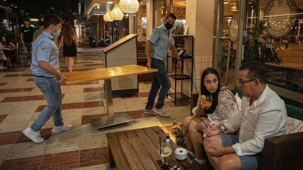 Unos camareros retiran mesas en un local de Platja d'Aro.