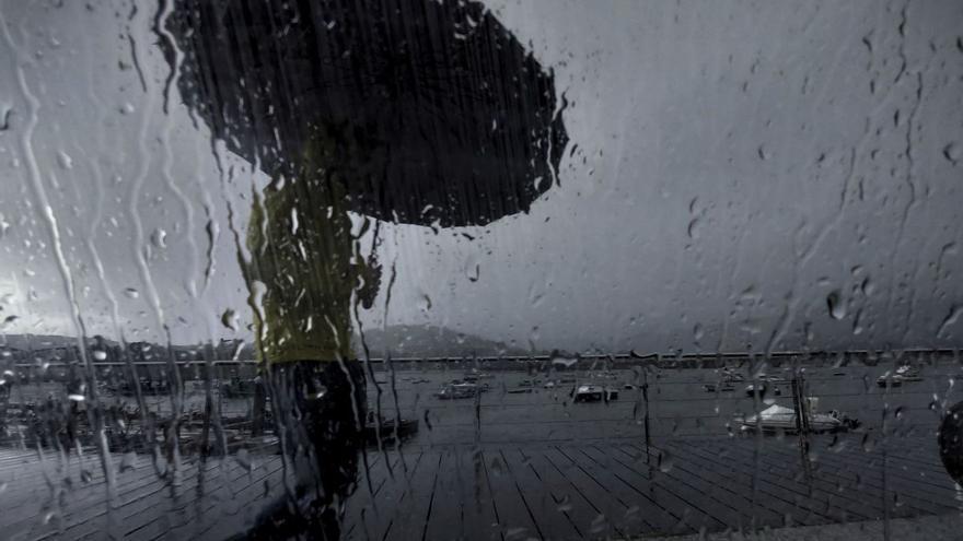 Un hombre se protege de la lluvia durante una de las borrascas de este otoño. |   // CABALAR