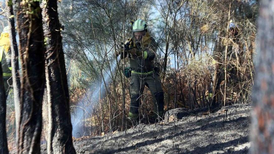Un bombero sofoca las llamas de un incendio en Taboexa. // Hernández