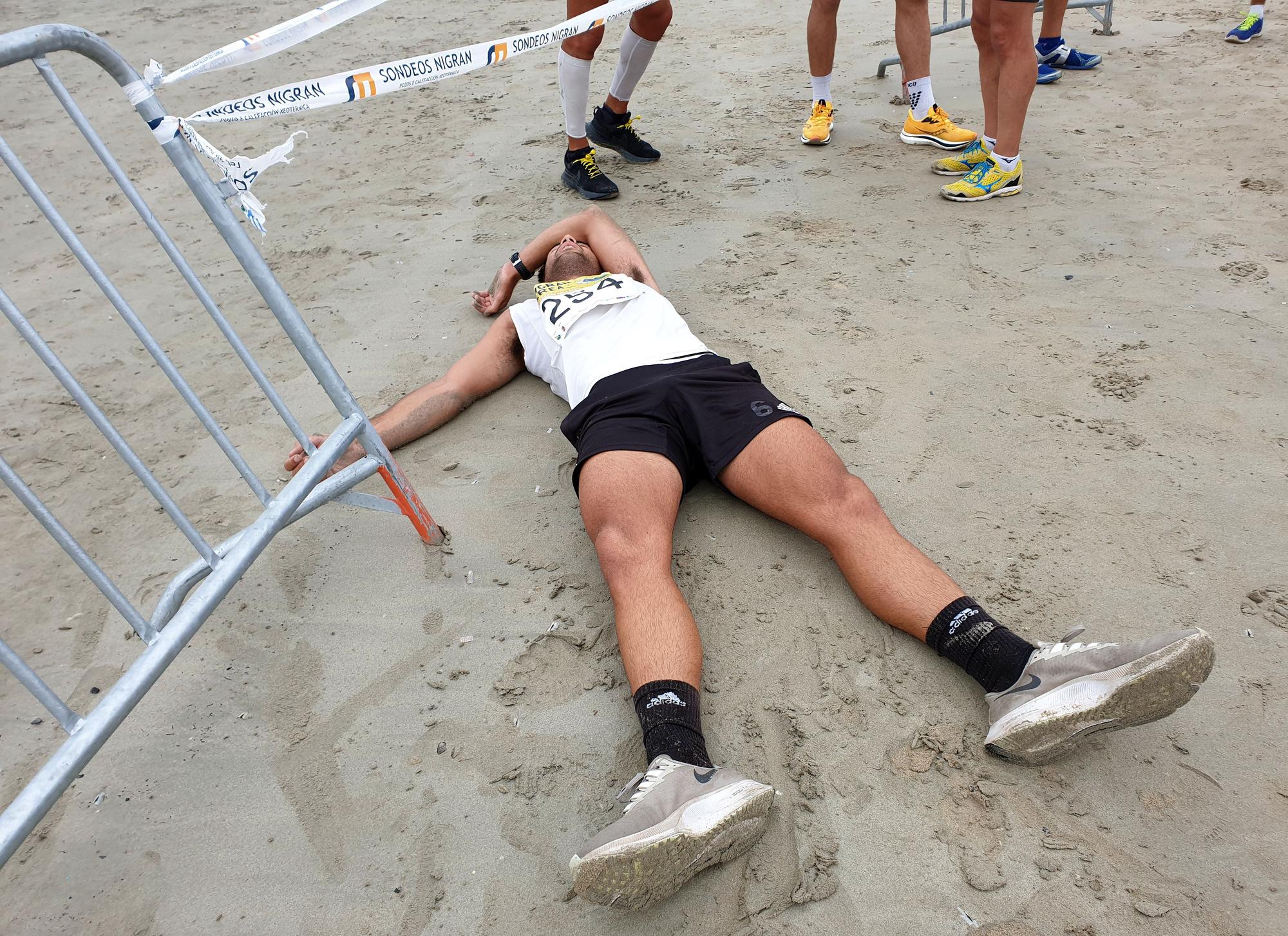 Un atleta, exhausto en el arenal. 