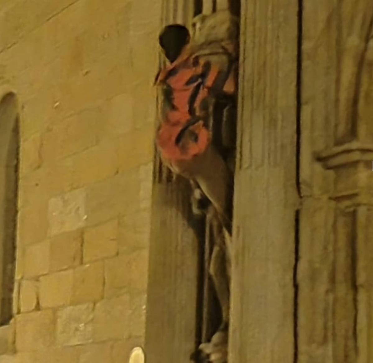 La persona, encaramada a la fachada