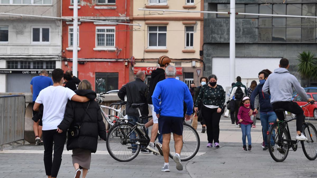 Ciudadanos con mascarilla en el paseo marítimo de A Coruña.