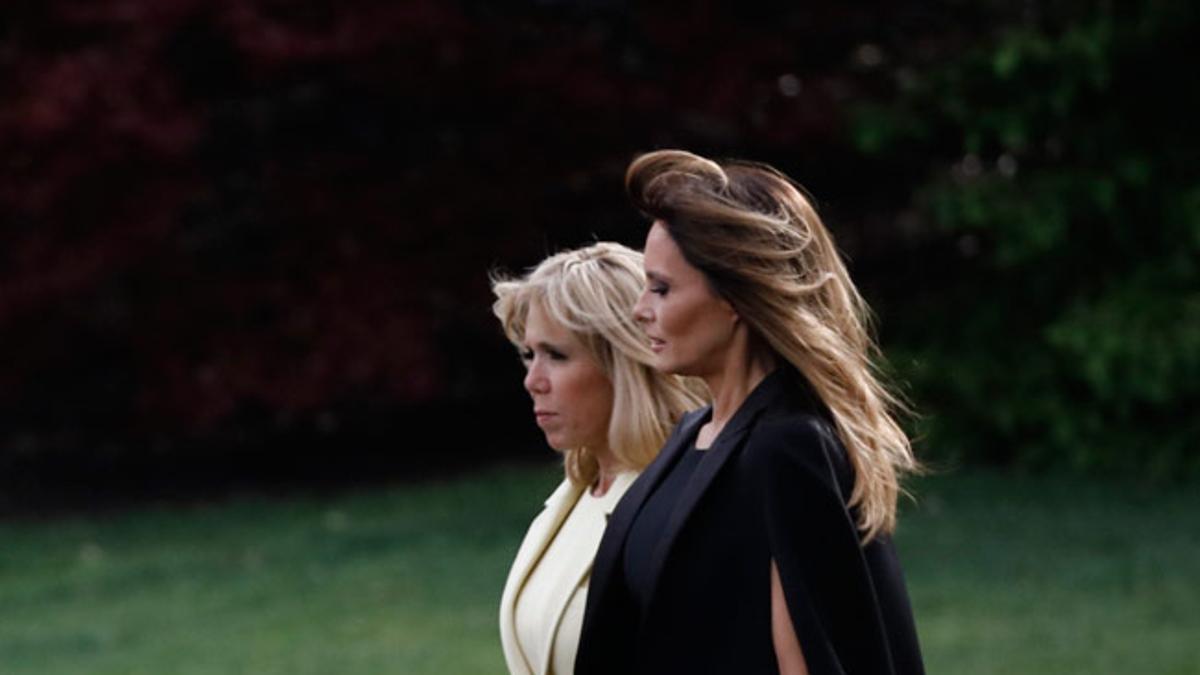 Brigitte Macron con abrigo de Louis Vuitton y Melania Trump con vestido capa de Dolce &amp; Gabbana