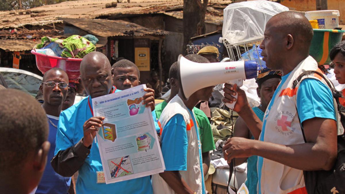 Personal sanitario muestra a la población cómo prevenir el contagio del virus del ébola, en Conakry.