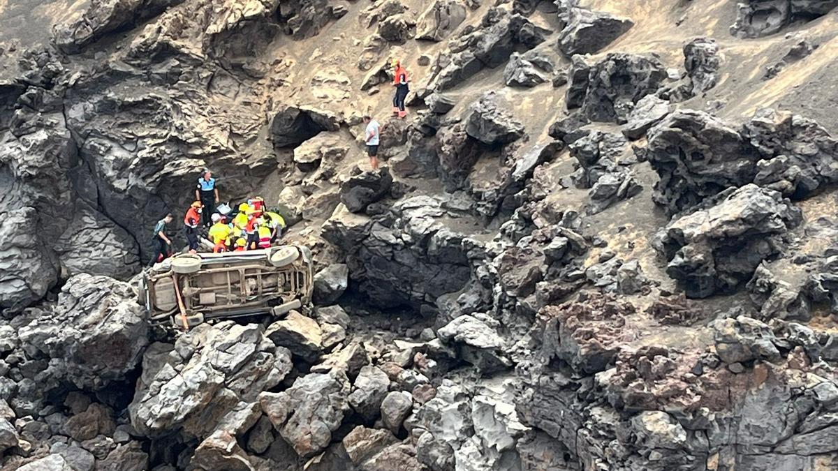 Los equipos de emergencia junto al coche precipitado.