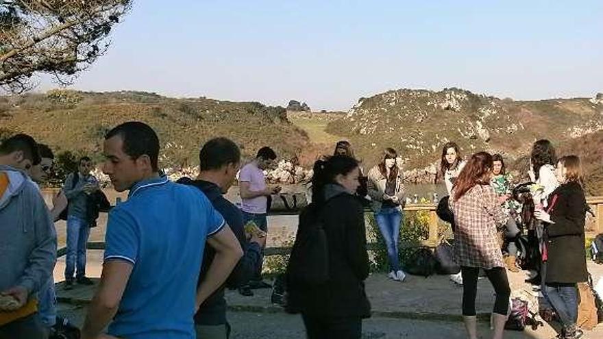 Varios figurantes reponen fuerzas al finalizar el rodaje en la playa de Poo.