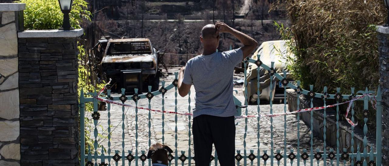 El veí Raúl Martínez observa l’impacte de l’incendi al davant de la seva llar precintada  | OSCAR BAYONA