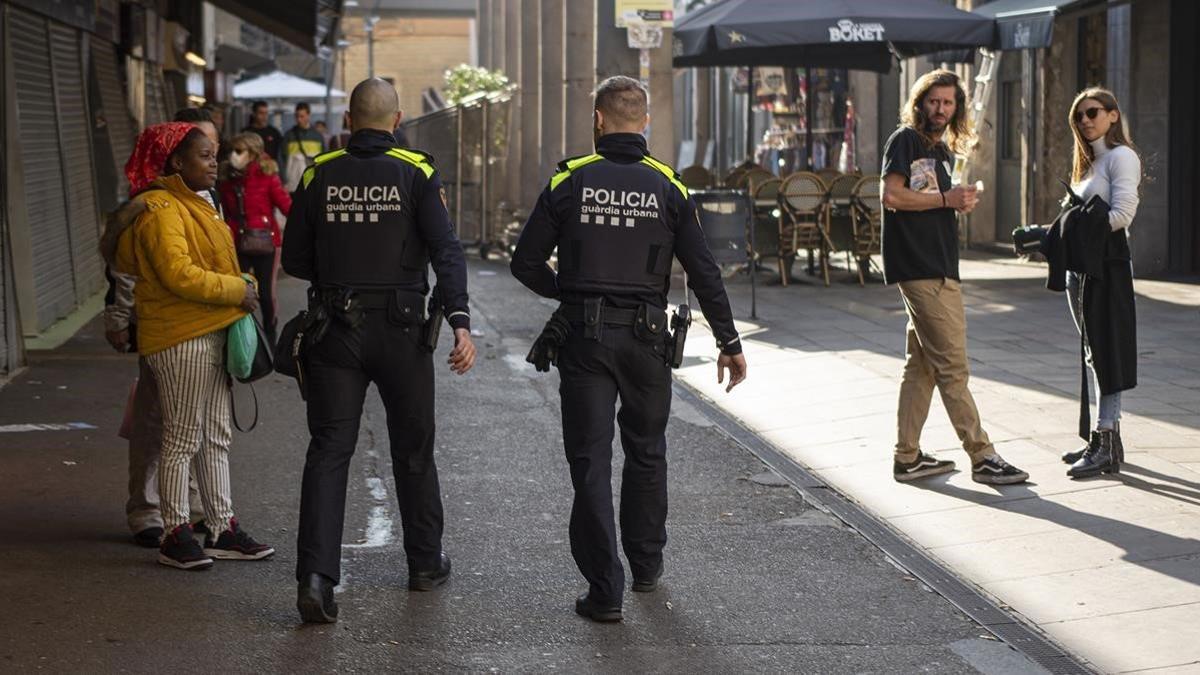 Dos agentes de la Guardia Urbana patrullan por el distrito de Ciutat Vella, ayer.