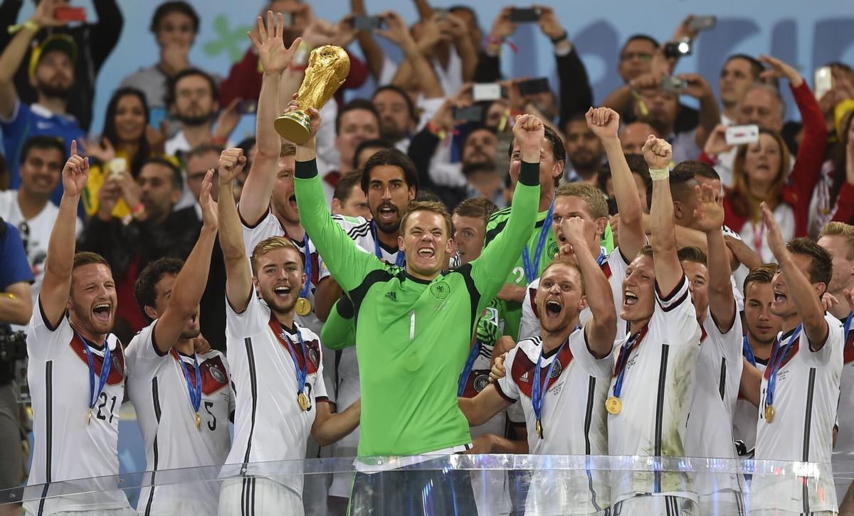 Germany's goalkeeper Manuel Neuer (front C) and team-mates celebrate with the World Cup trophy after they won the 2014 FIFA World Cup final football match between Germany and Argentina 1-0 following extra-time at the Maracana Stadium in Rio de Janeiro, Brazil, on July 13, 2014. AFP PHOTO / FABRICE COFFRINI. HORIZONTAL