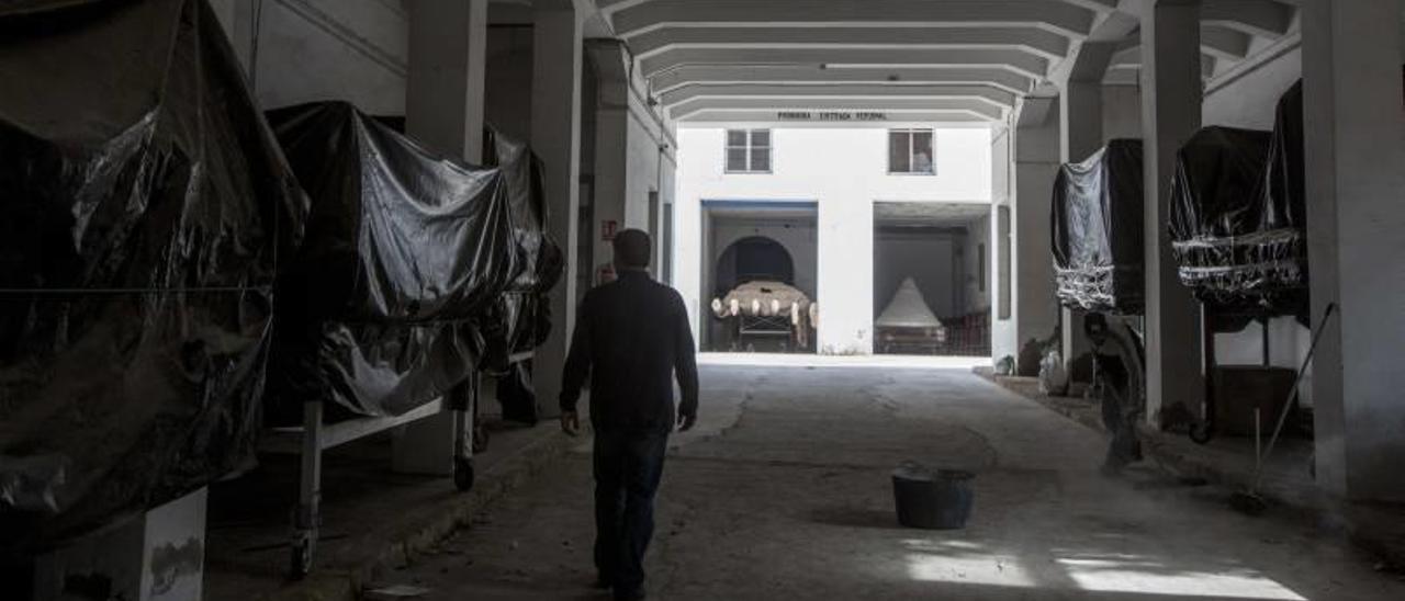 Tronos de Semana Santa se alinean cubiertos por plásticos en una nave de Las Cigarreras.